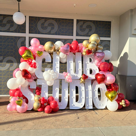 Outdoor LED marquee letters with pink, red, white and gold balloon garland for Club Studio Grand Opening in Westchester, Los Angeles — Marina Balloons