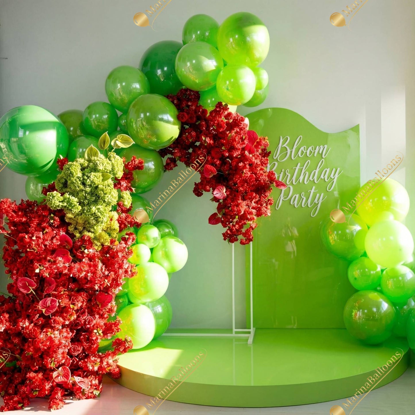 A vibrant green-and-red floral balloon setup with lush blooms and glossy balloons - a bold, garden-inspired backdrop for a bright and unforgettable birthday celebration.