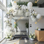 A clean, modern white-and-silver balloon arch with elegant florals - an elevated decor choice for corporate lobbies, openings, and professional events.